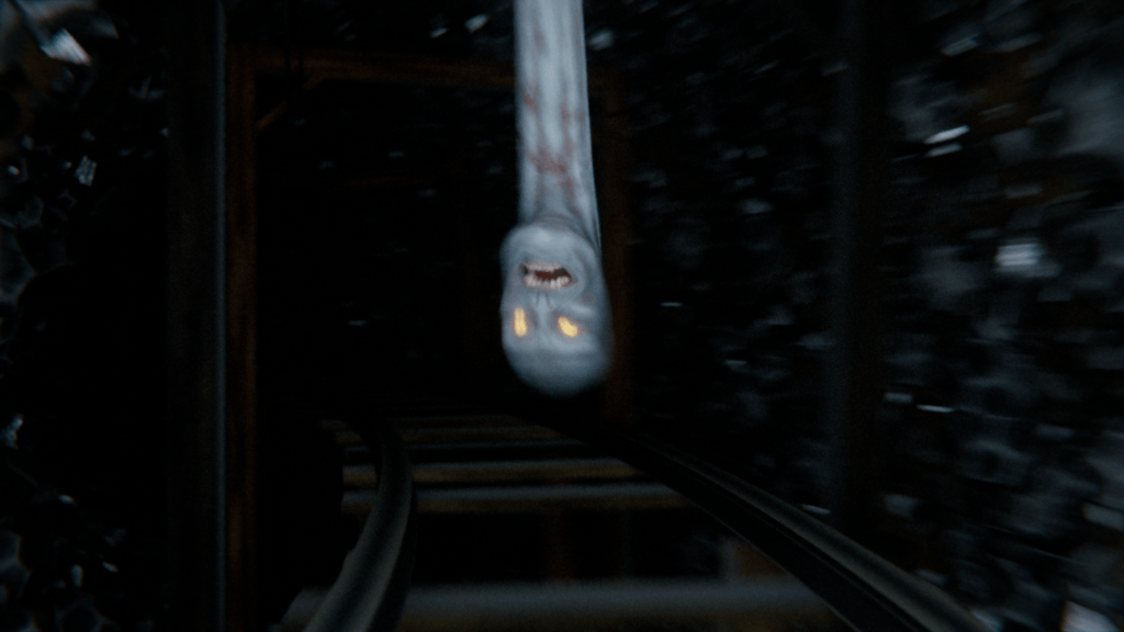 A ghostly figure with glowing yellow eyes appears to be emerging from a dark tunnel, with train tracks visible in the foreground.